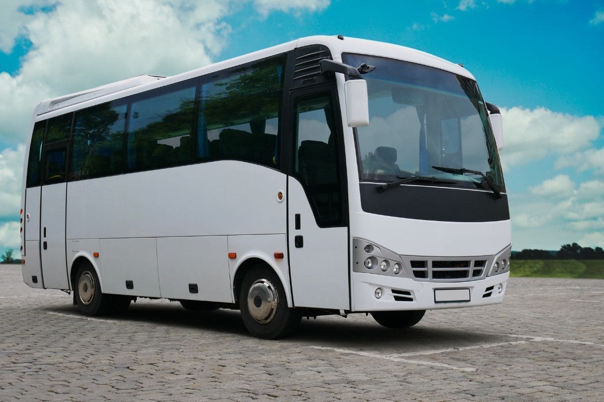 Showcasing a white empty bus is parking in an open area