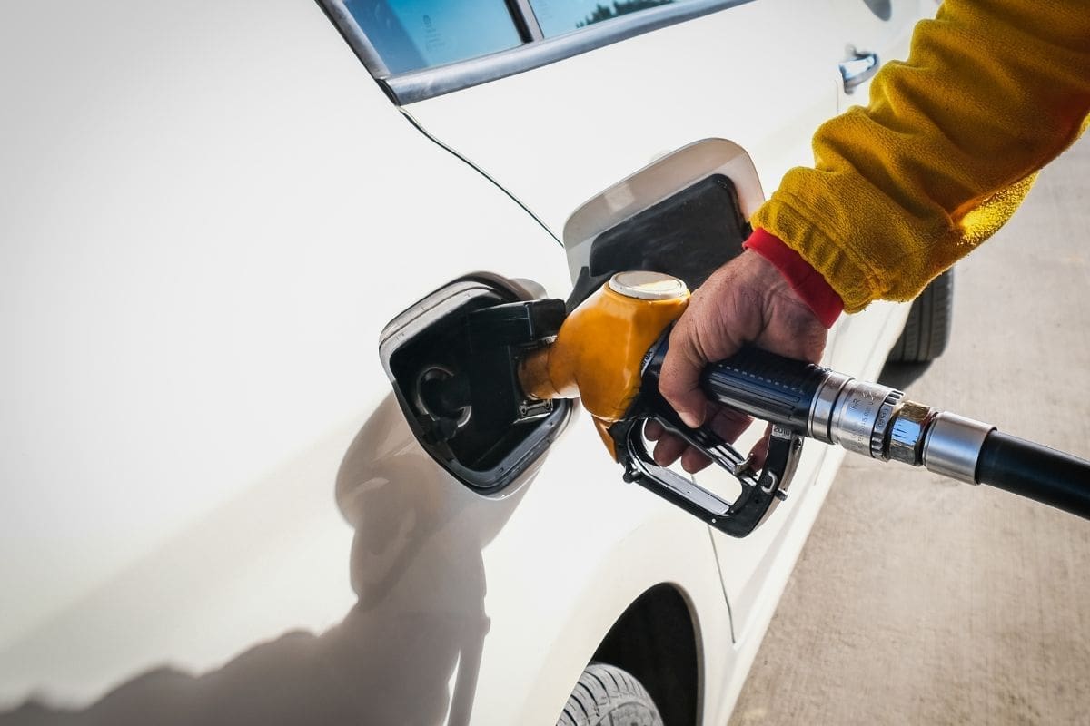 Gas pump attendant is fueling up the vehicle